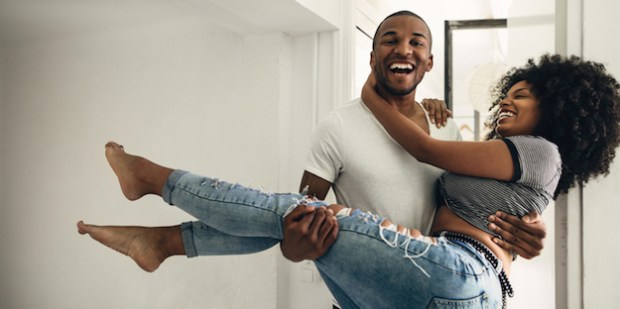black-couple-laughing-carrying-woman